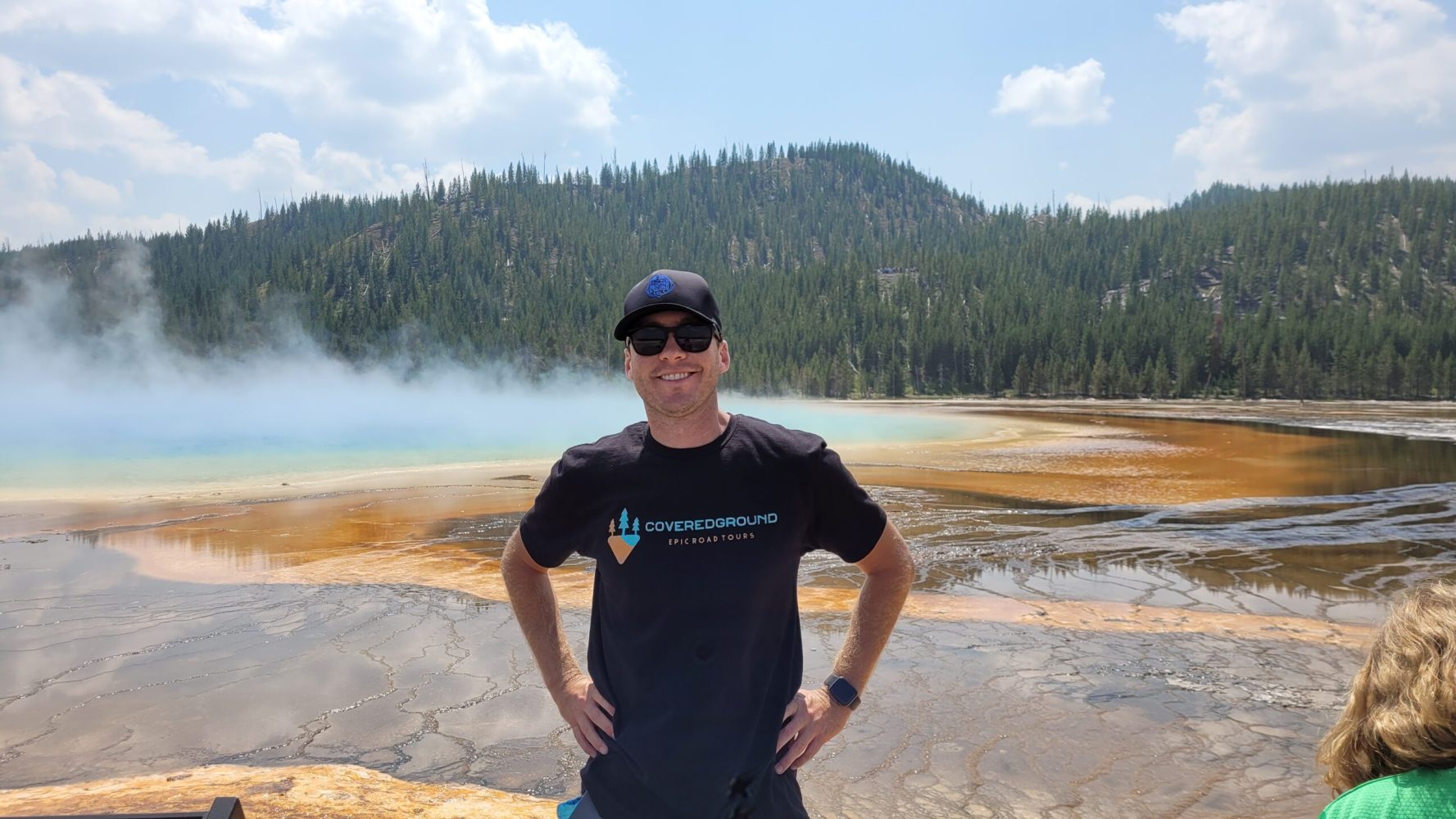 a man standing next to a lake